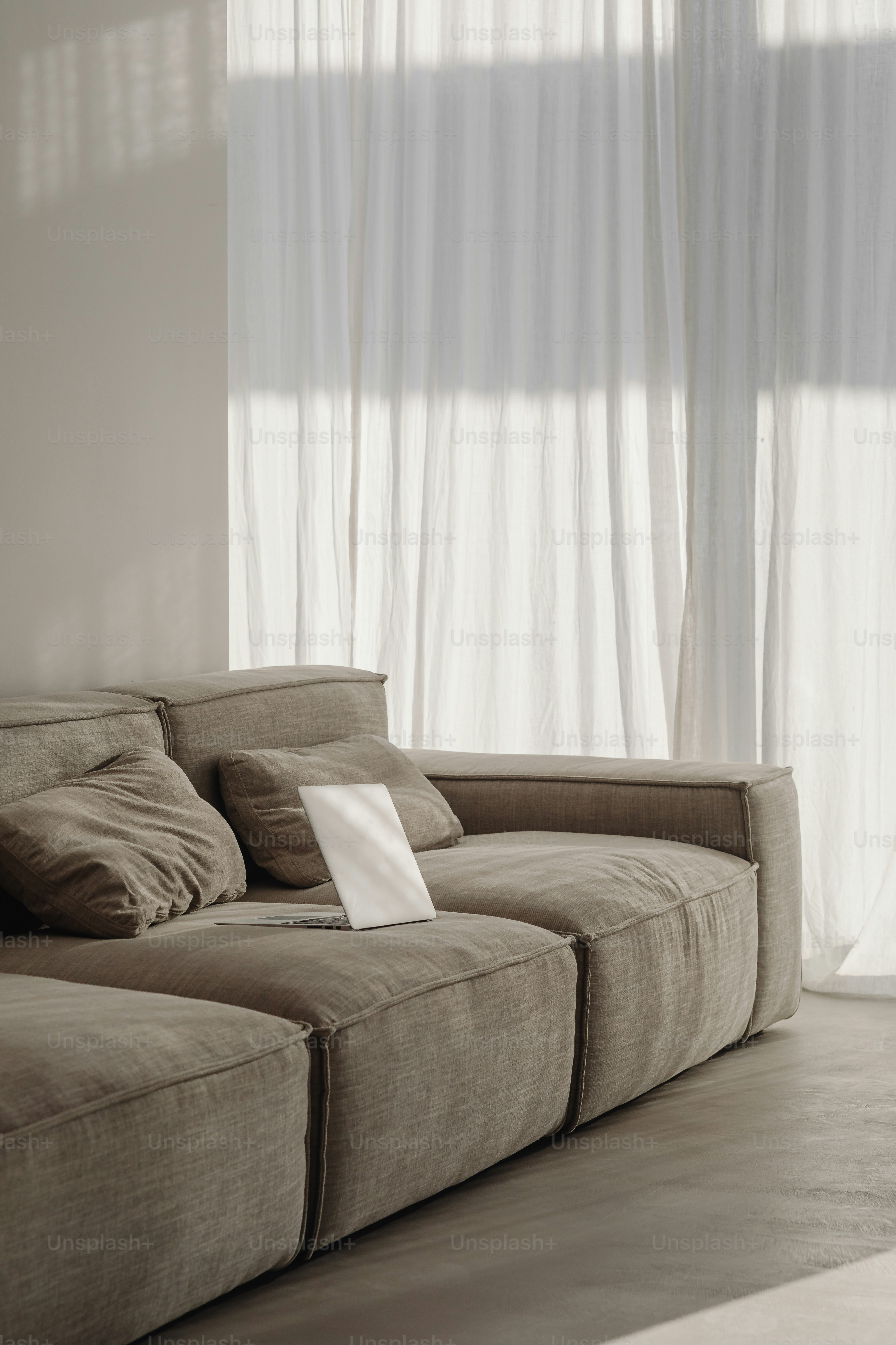a couch sitting in front of a window with a sheet of paper on it